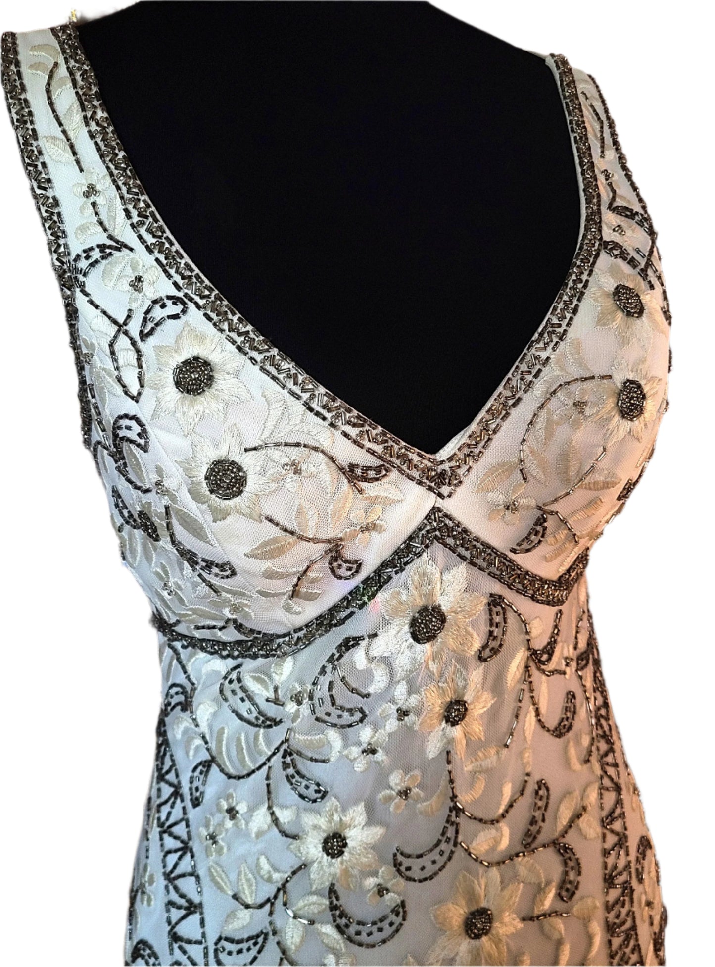 White dress with floral embroidery and sequins on a mannequin.